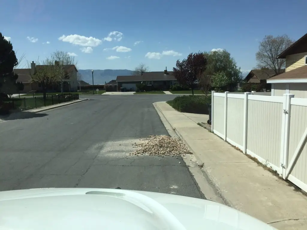 Big pile of rocks blocking street sweeper's way.
