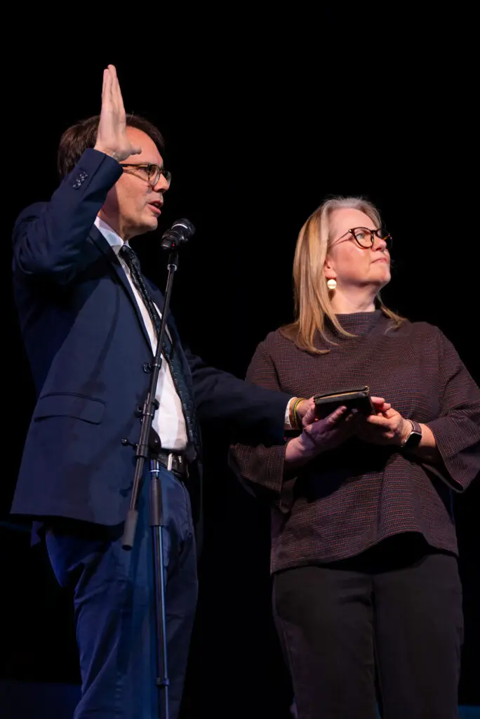 Quinn Mecham takes the oath of office while his wife holds the Bible