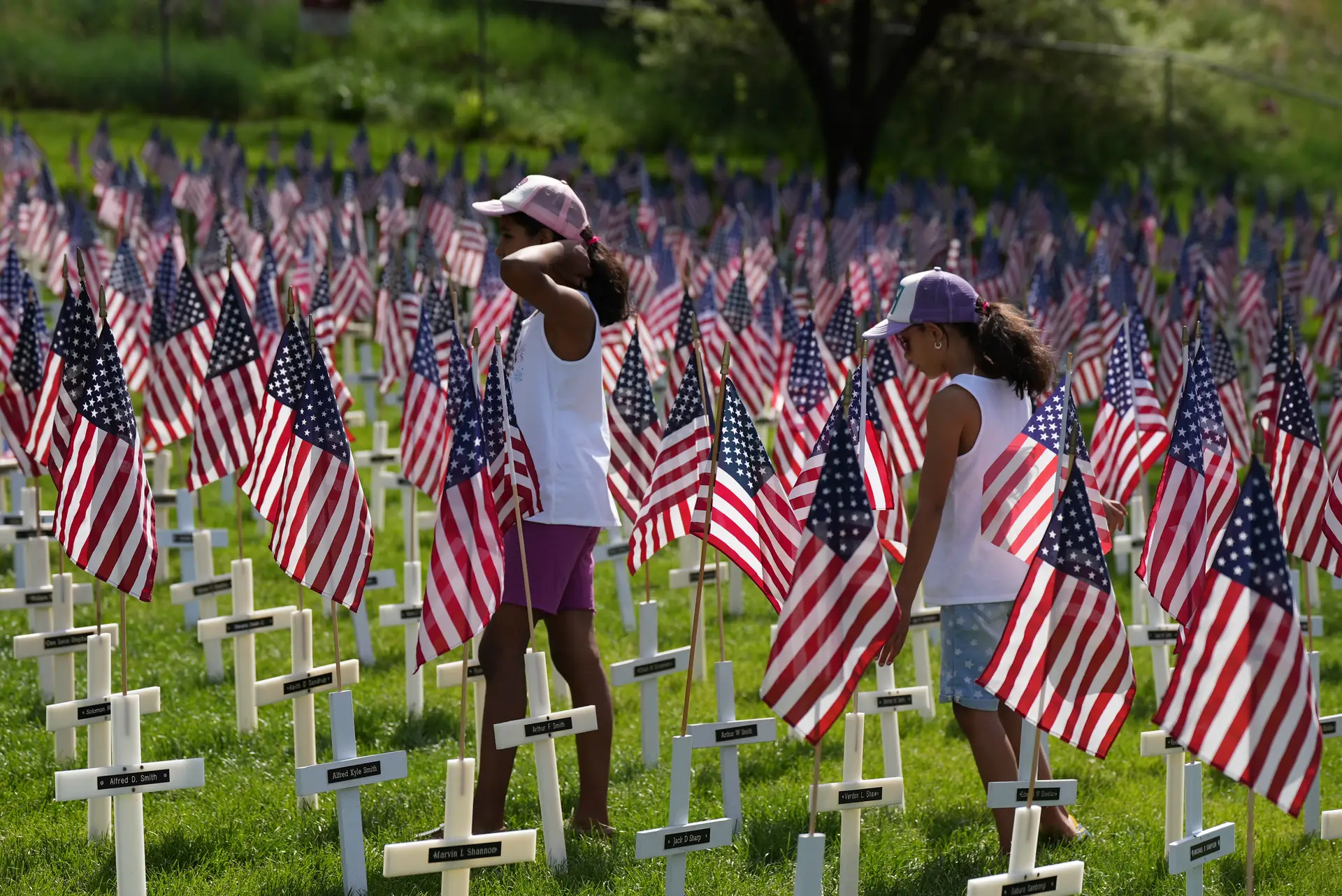 Two girls walking through the American flag.